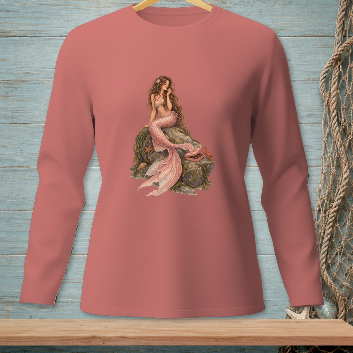 Long-sleeve shirt with a printed illustration of a mermaid sitting on a rock.