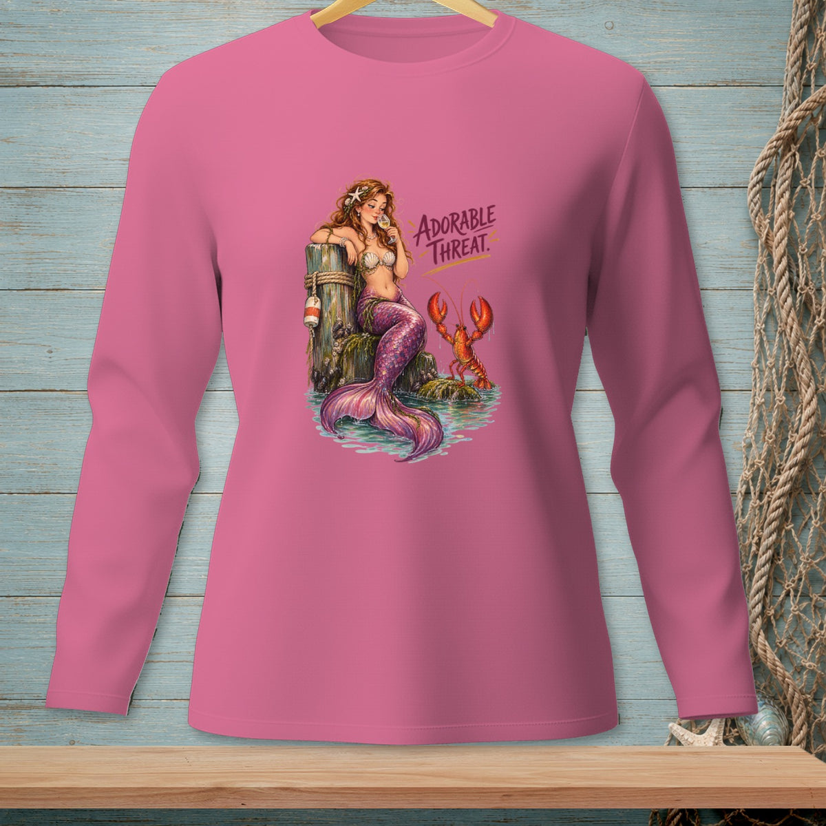 Mermaid and lobster graphic with text "Adorable Threat" on pink shirt.