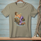 Mermaid relaxing on rocks with a drink and a crab, printed on a tan t-shirt.