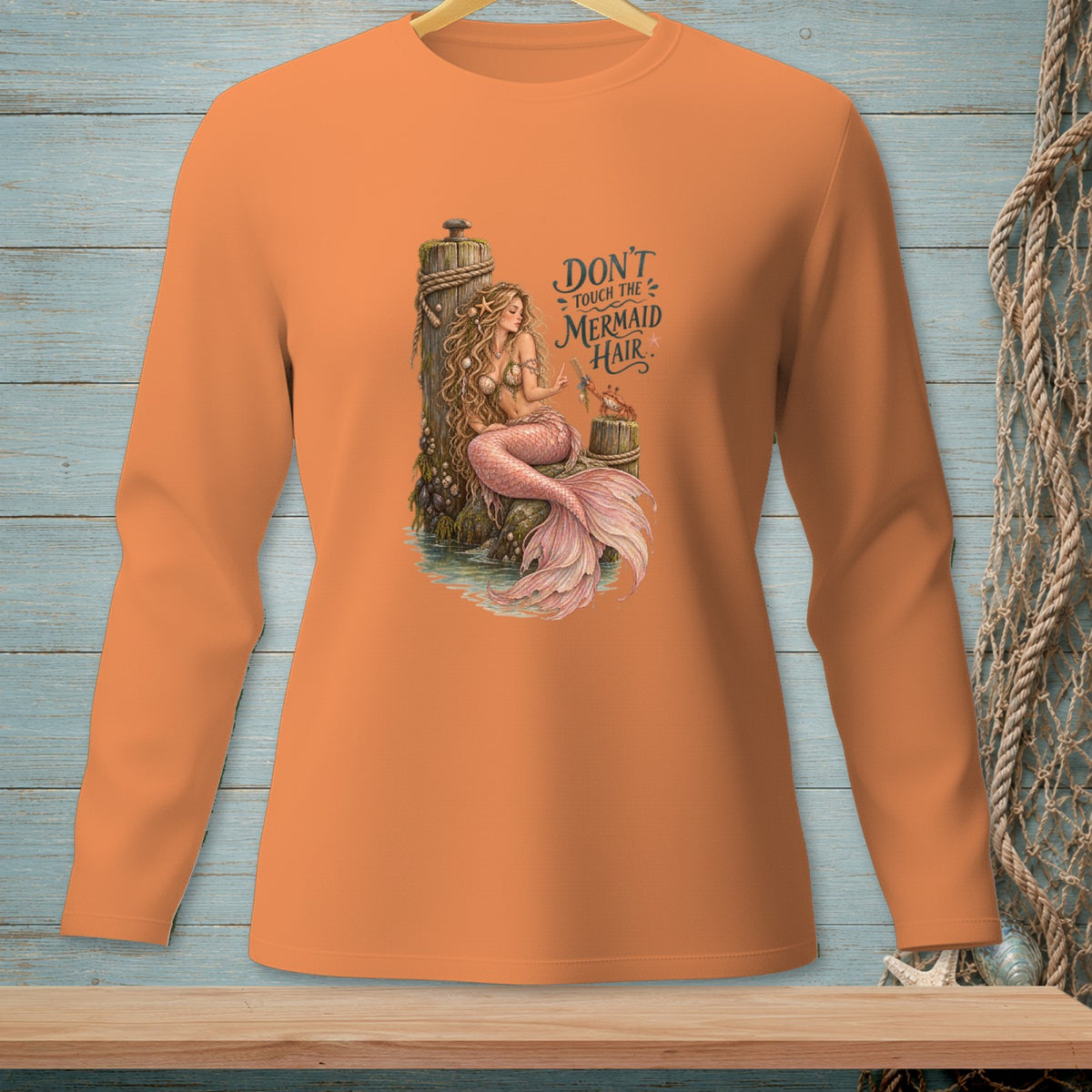 Orange long-sleeve shirt with a mermaid illustration and text "Don't Touch The Mermaid Hair".
