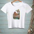 White t-shirt graphic of a mermaid on a dock with text "Whatever Floats Your Boat."