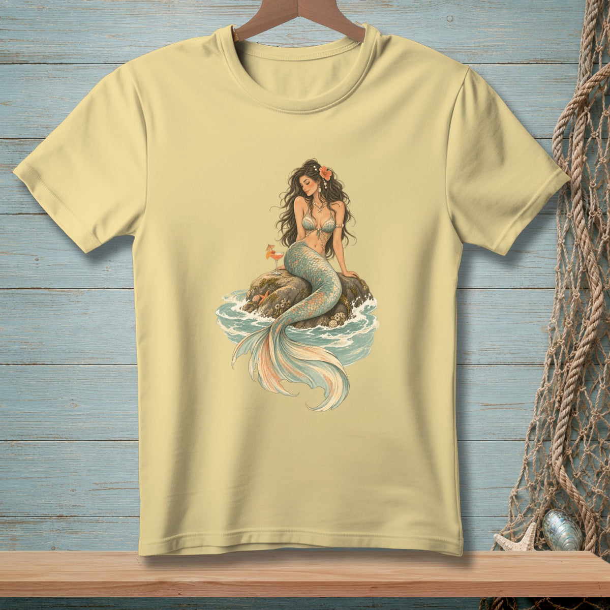 Yellow t-shirt with a vintage illustration of a mermaid on a rock.