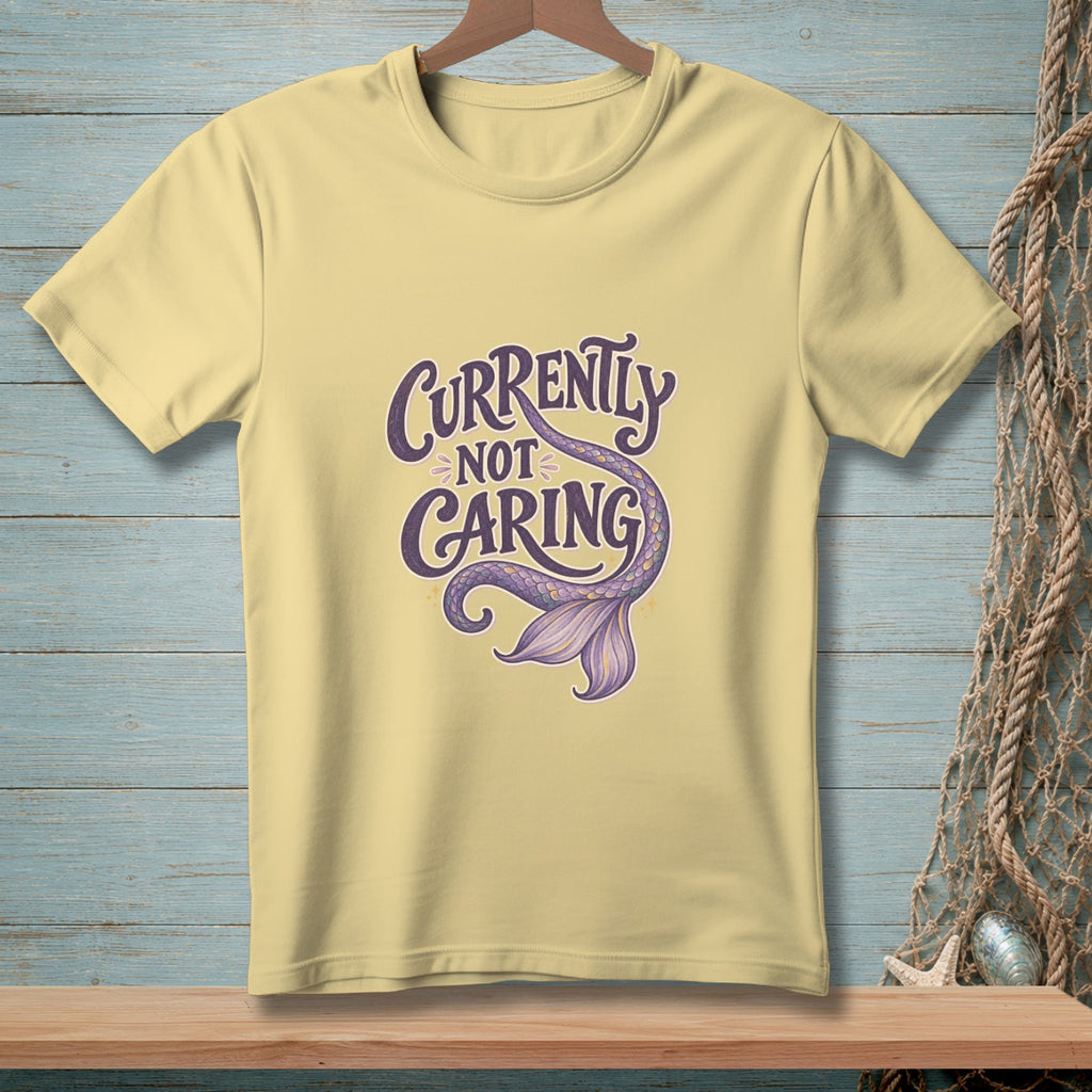 Light yellow t-shirt with "Currently Not Caring" and a mermaid tail graphic.