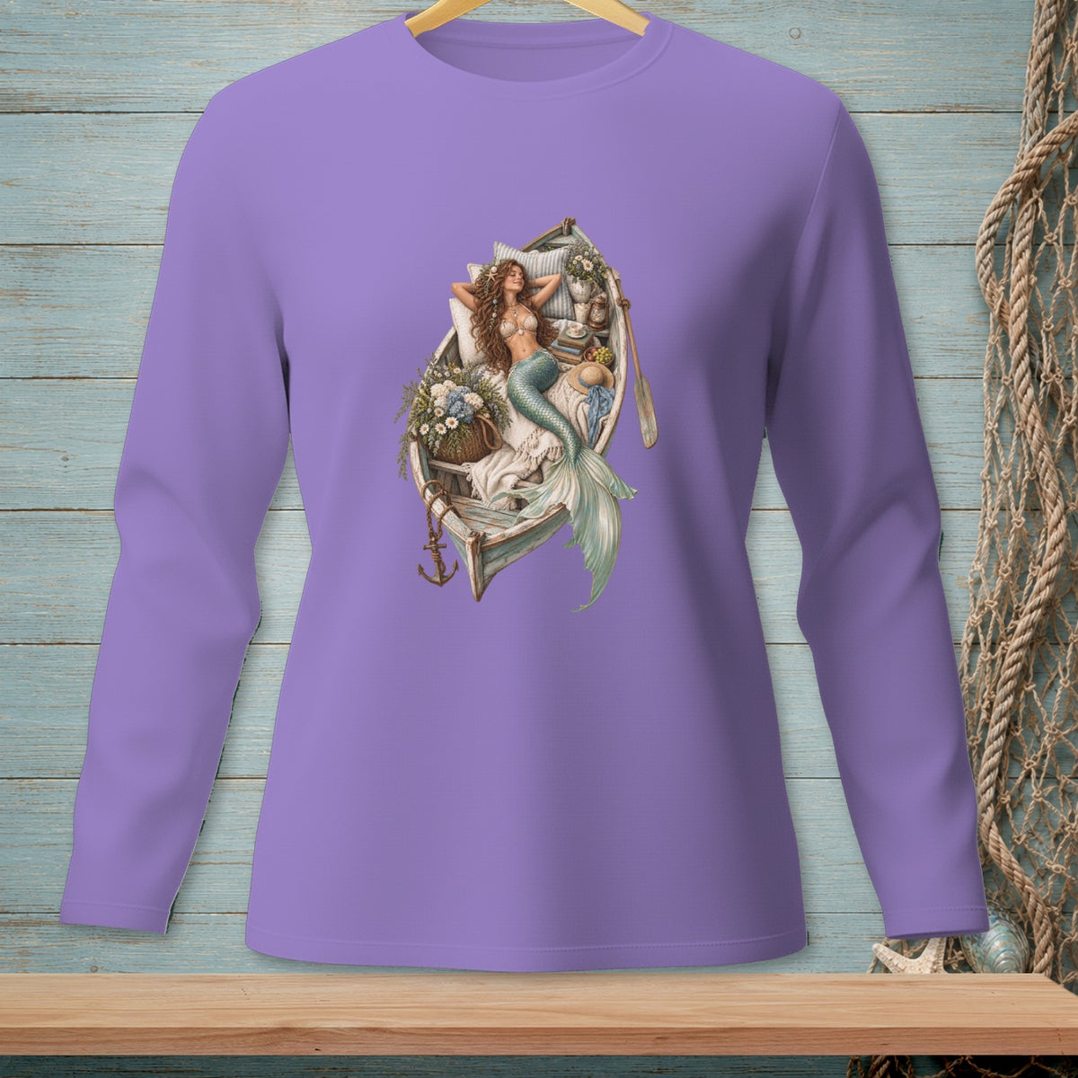Lavender shirt with a graphic of a mermaid resting in a boat filled with flowers and an oar.