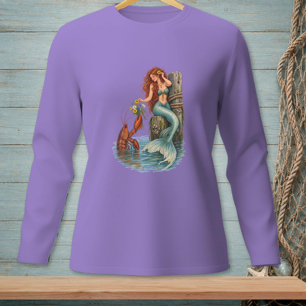 Mermaid with flowers and lobster by a wooden post in water graphic on a purple long-sleeve shirt.