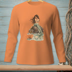 Long sleeve orange shirt with a mermaid sitting on rocks by the sea.