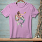 Pink t-shirt with watercolor graphic of a mermaid holding a pufferfish and leaning on a buoy.