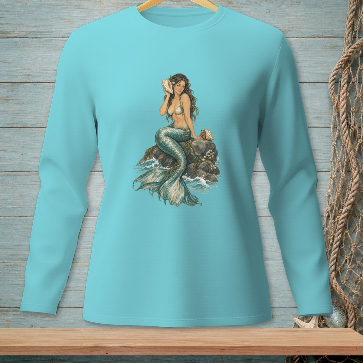 Teal long-sleeve shirt with a detailed mermaid graphic holding a shell.