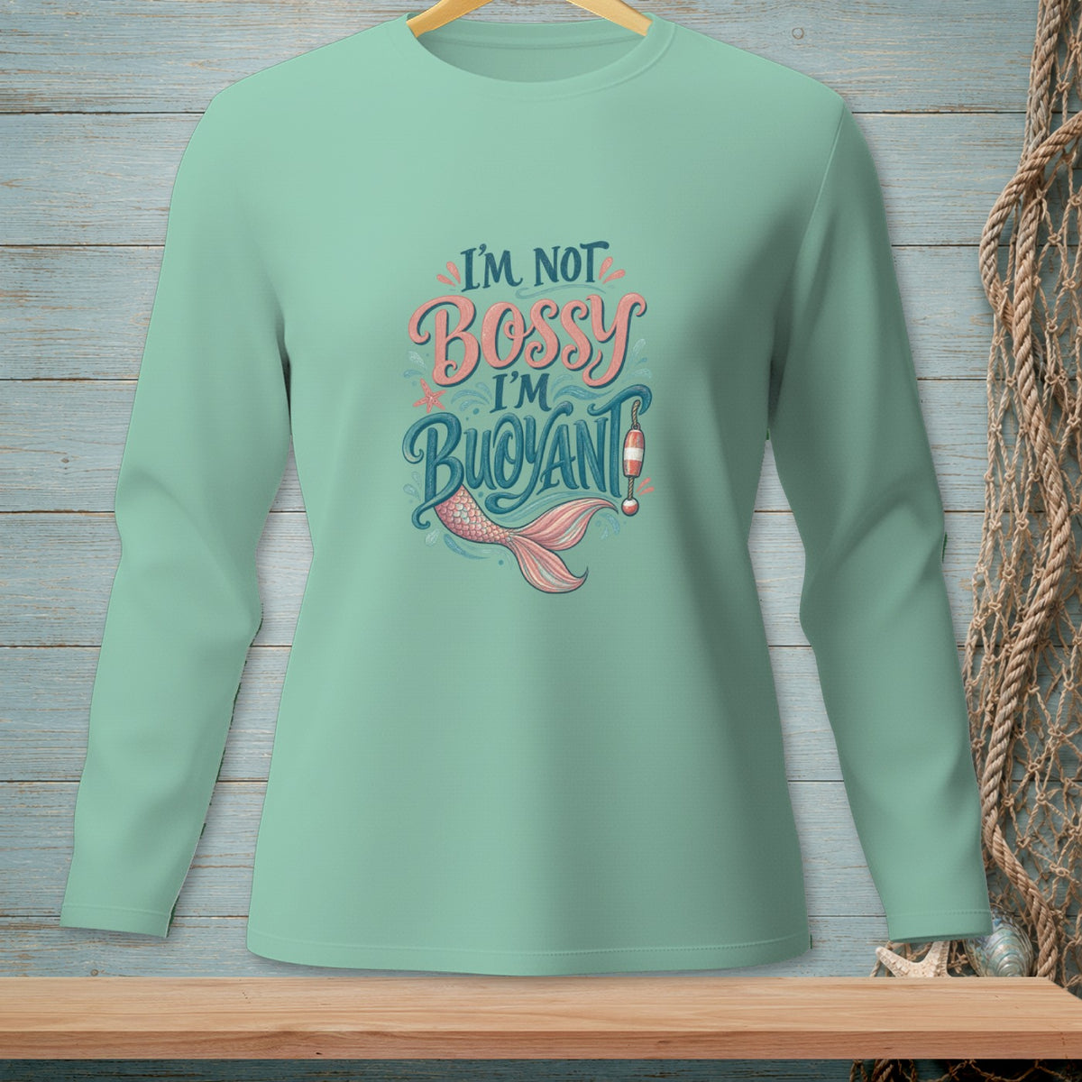 Light teal long-sleeve shirt with "I'm not bossy, I'm buoyant" text and mermaid tail.