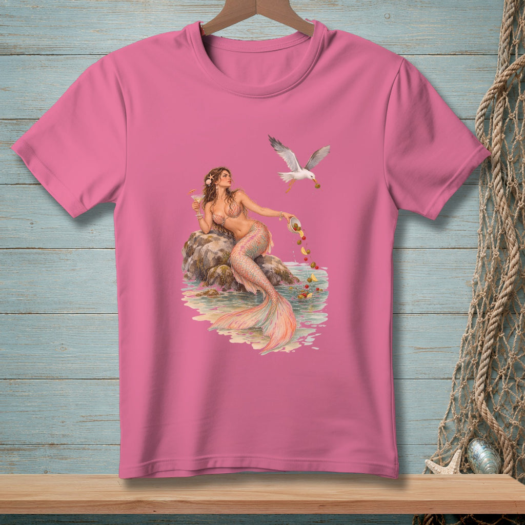 Pink t-shirt with watercolor graphic of a mermaid and a seagull near a rocky shore.