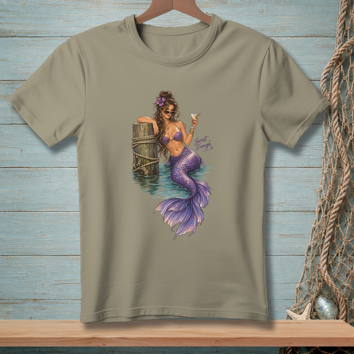Tan t-shirt with a mermaid leaning on a post, holding a drink. Text reads "Sweet Enough".