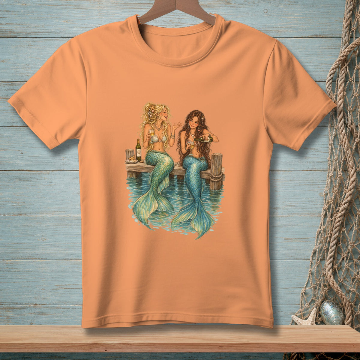 Two mermaids with blue tails drink from wine bottles on a dock.