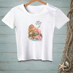White t-shirt with a pink mermaid on a rock, holding a drink and a crab with text.