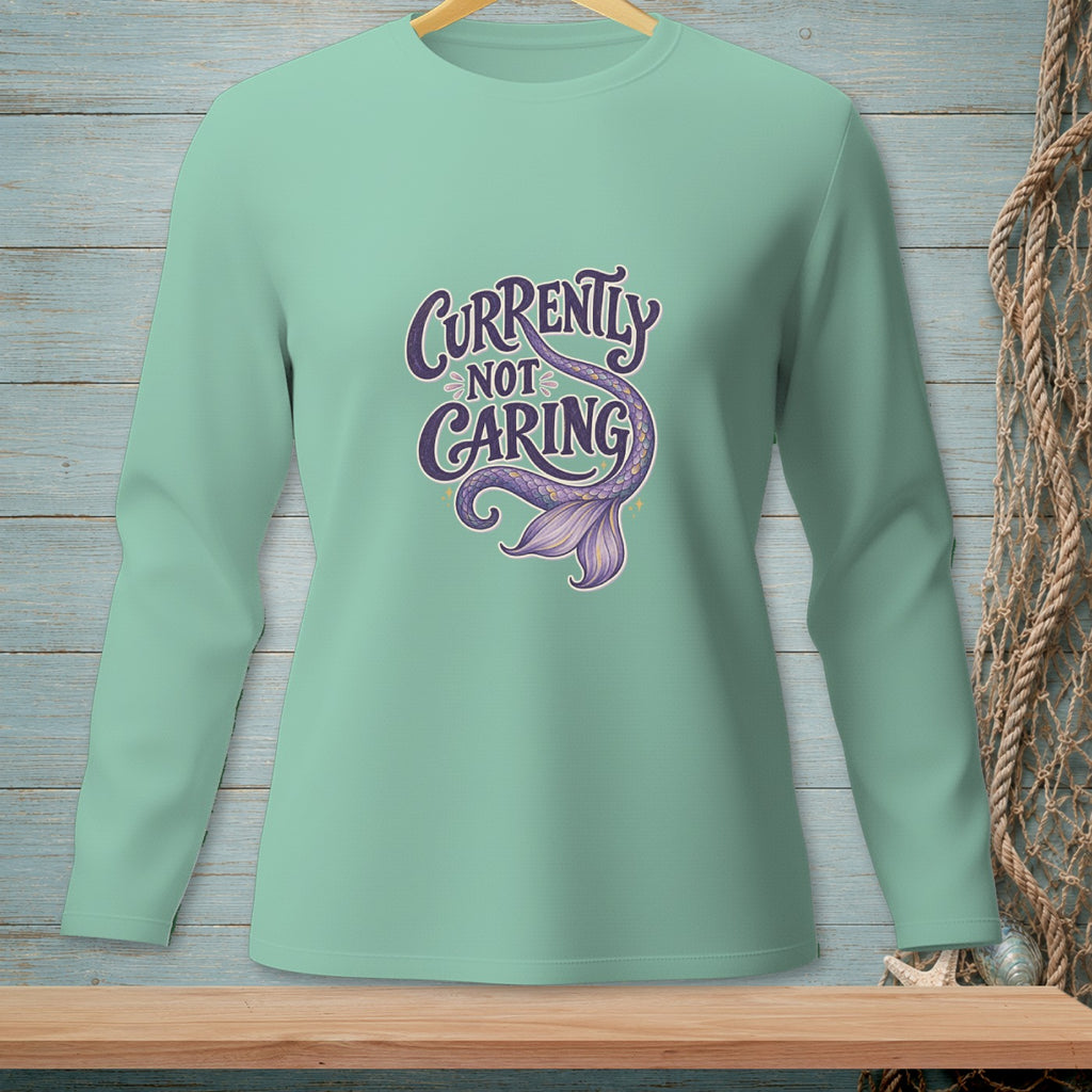 Mint green long sleeve shirt with "Currently Not Caring" and a mermaid tail graphic.