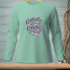 Mint green long sleeve shirt with "Currently Not Caring" and a mermaid tail graphic.