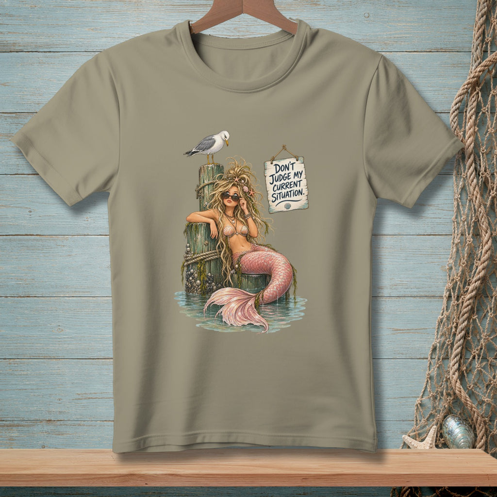 T-shirt graphic of a mermaid on a pilothouse with a seagull and sign saying "Don't Judge My Current Situation."