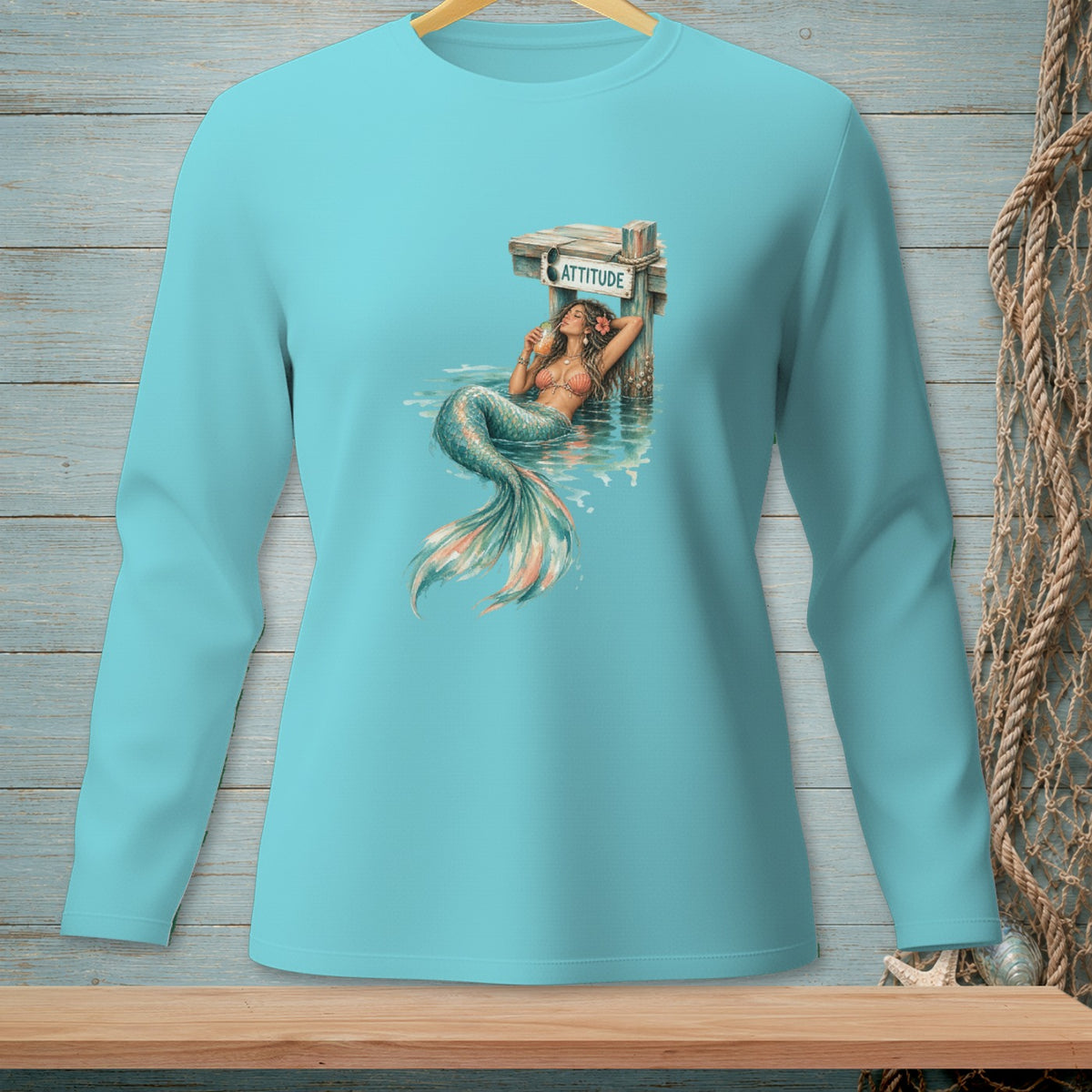 Mermaid with drink relaxes by a dock with sign that reads ATTITUDE.