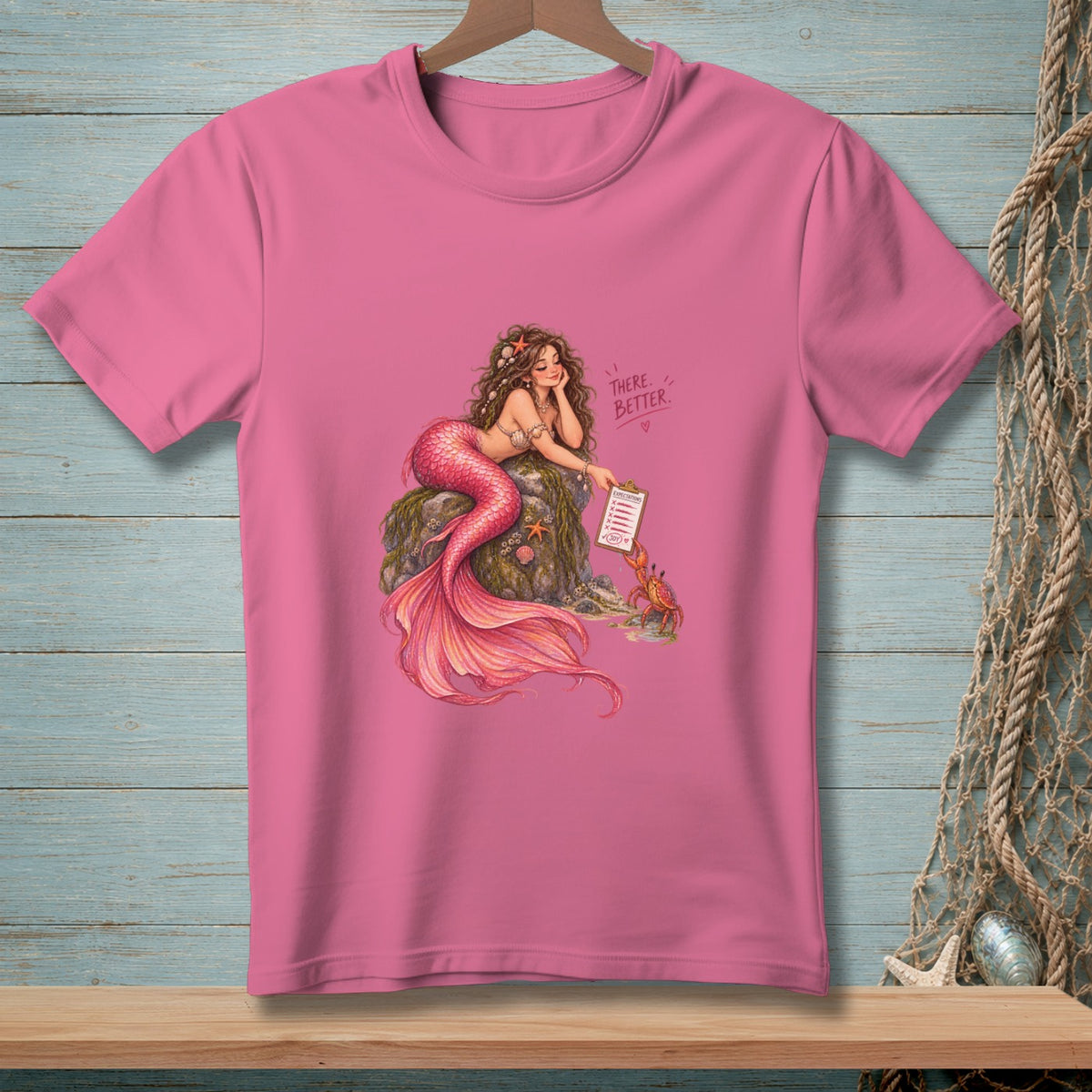 Pink t-shirt with illustration of a mermaid and crab on rocks, text reads "There. Better."