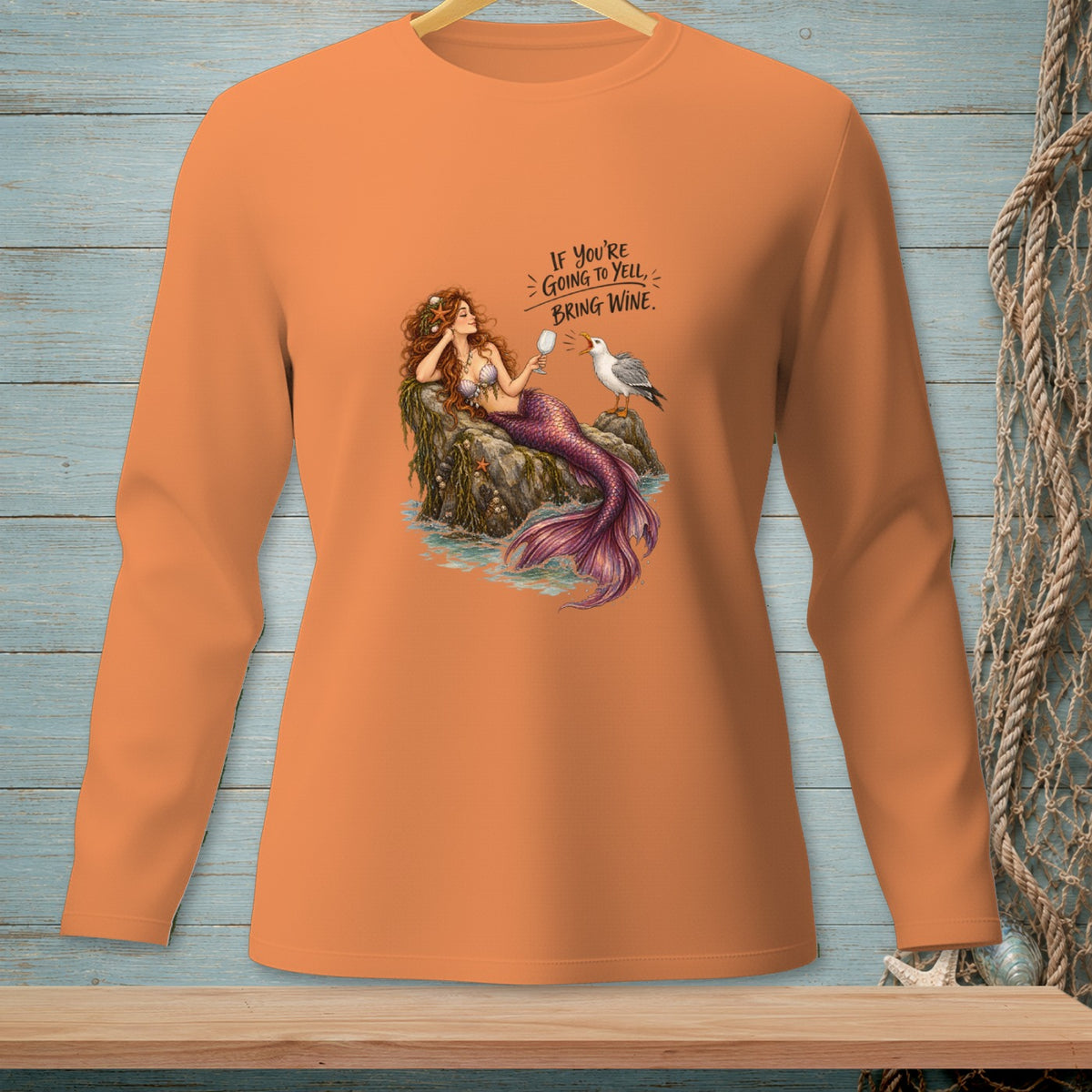 Orange long-sleeve shirt with a mermaid, seagull, and text.