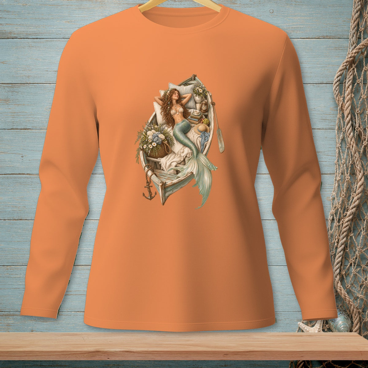 Orange long-sleeve shirt with a graphic of a mermaid in a boat.