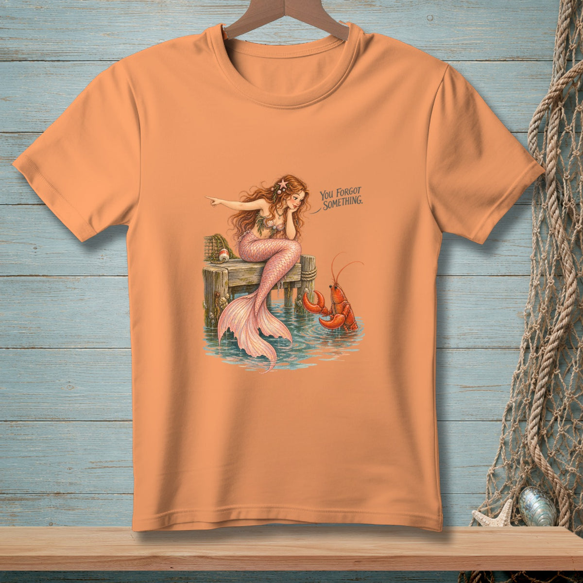 Mermaid with pink tail on dock points to lobster, text reads "You Forgot Something."