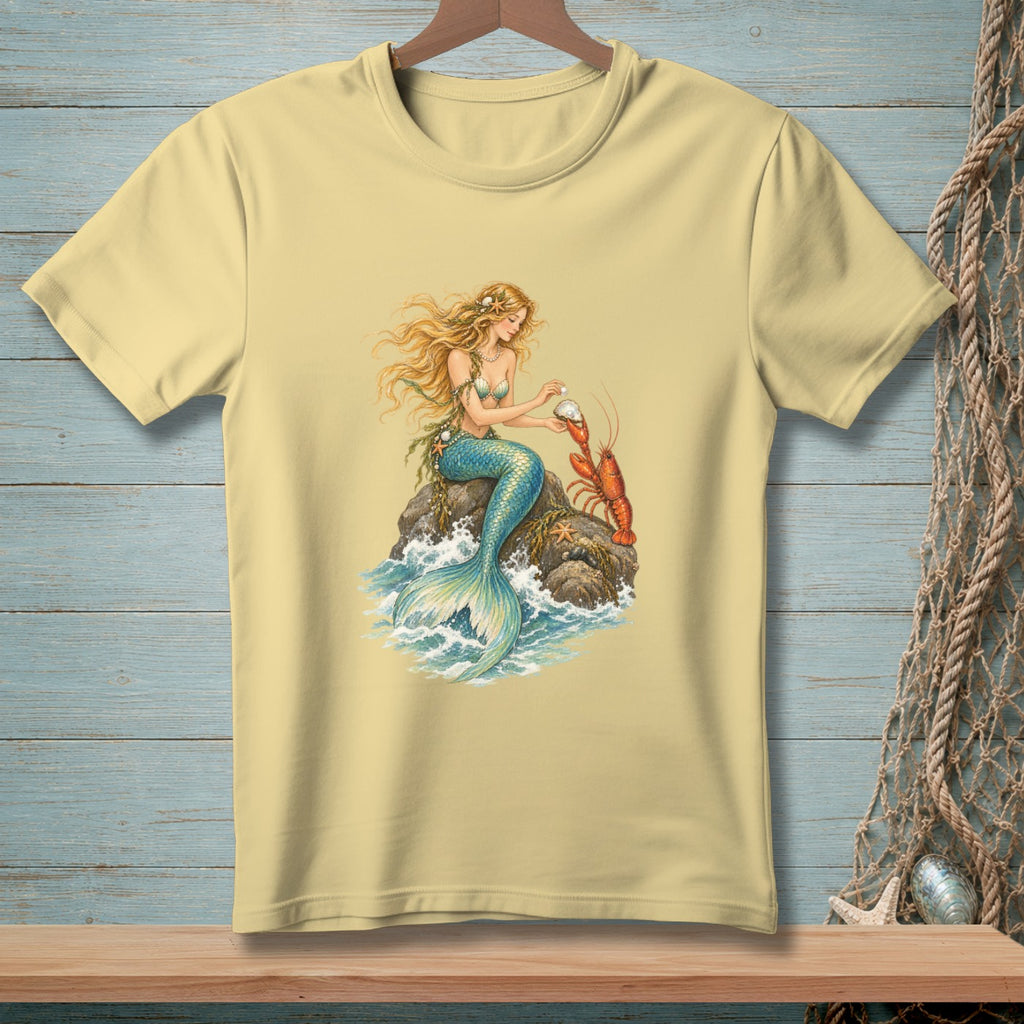 Pale yellow t-shirt with a mermaid holding a pearl and a lobster on a rock.