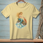Pale yellow t-shirt with a mermaid holding a pearl and a lobster on a rock.