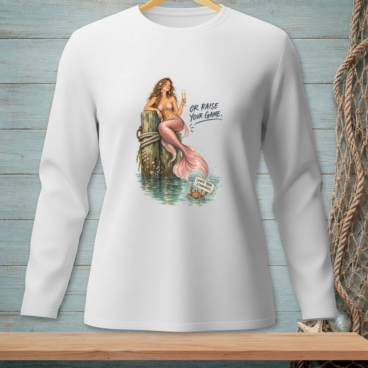 Long sleeve white shirt with a mermaid, text "Or Raise Your Game", and a crab.