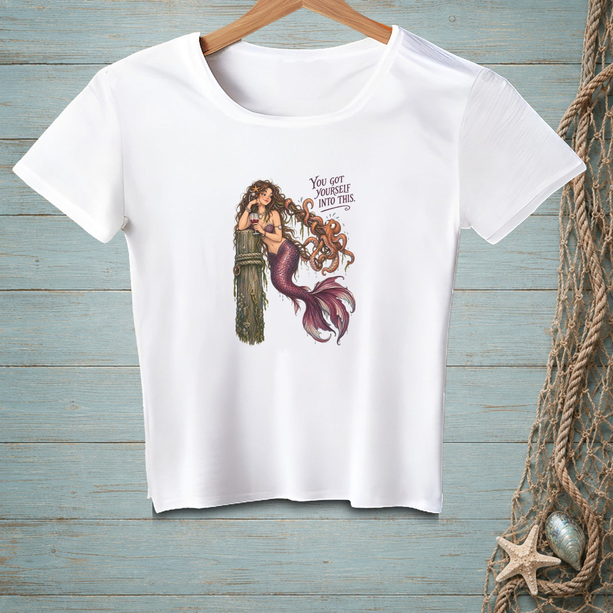 White t-shirt with a mermaid and octopus graphic and text.