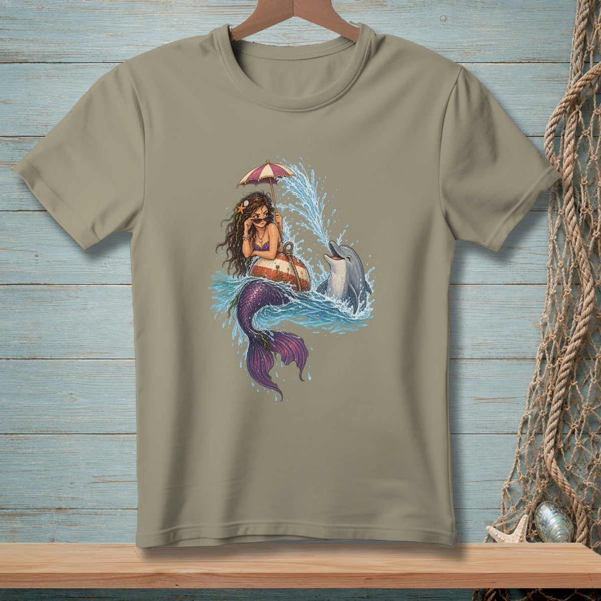 Mermaid with umbrella and sunglasses floats with a dolphin splashing water.