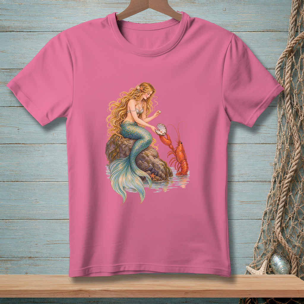 Pink t-shirt with a mermaid sitting on a rock, holding a pearl with a lobster nearby.