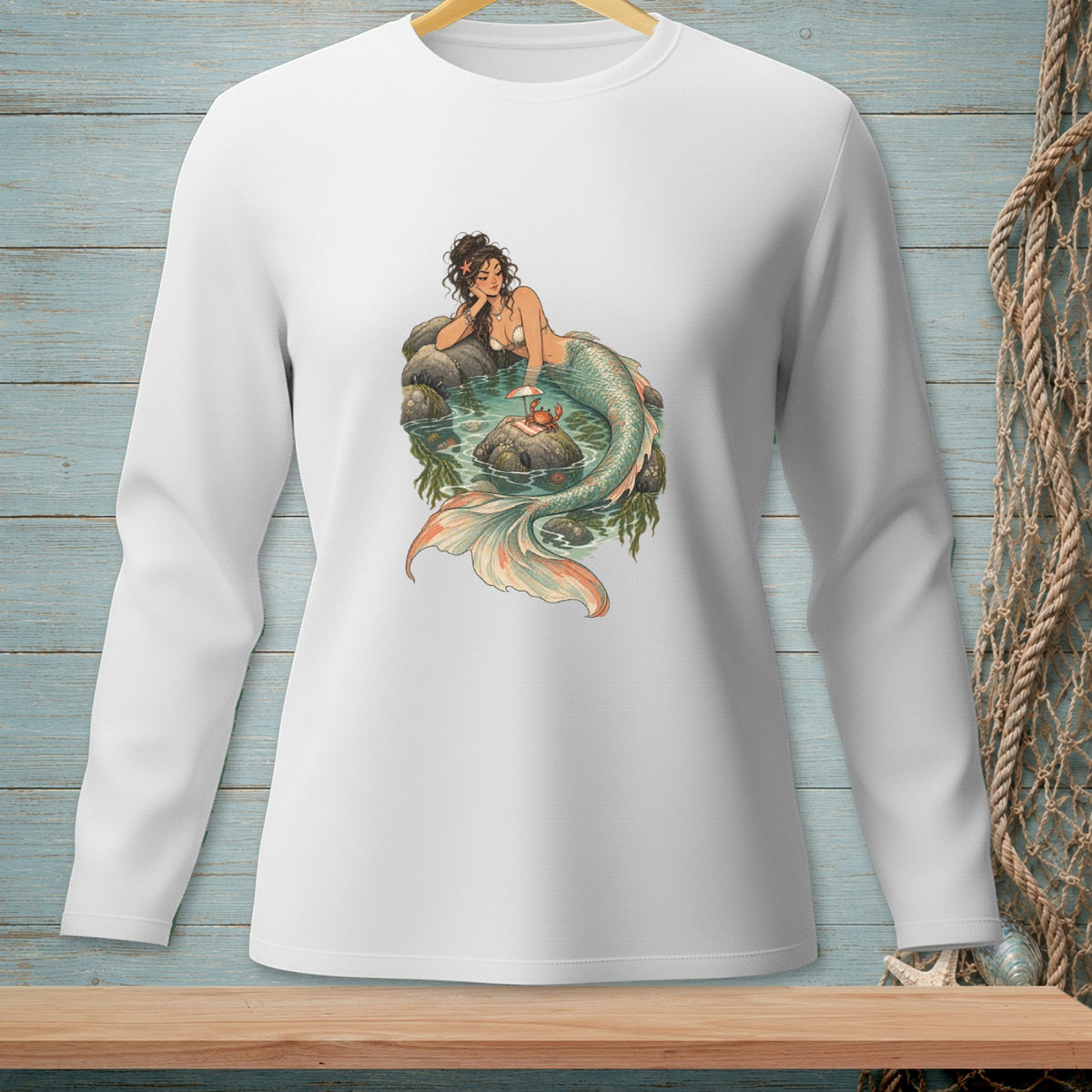 White long-sleeve shirt with a graphic of a mermaid on rocks in water.