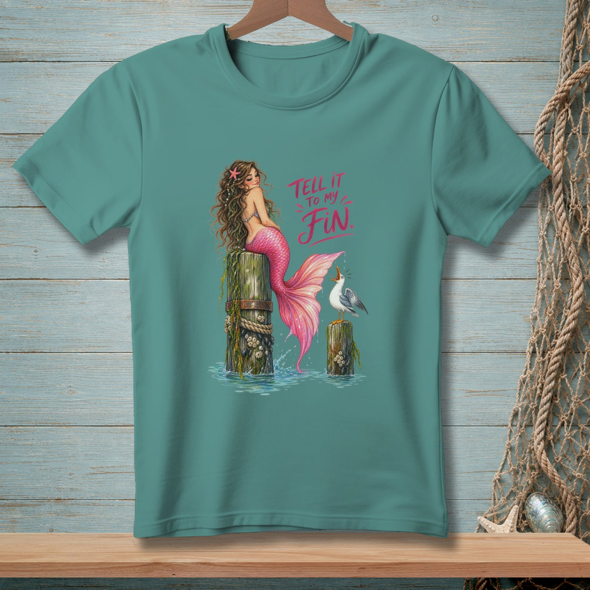 Mermaid with pink tail on a post with a seagull and text "Tell it to my Fin".