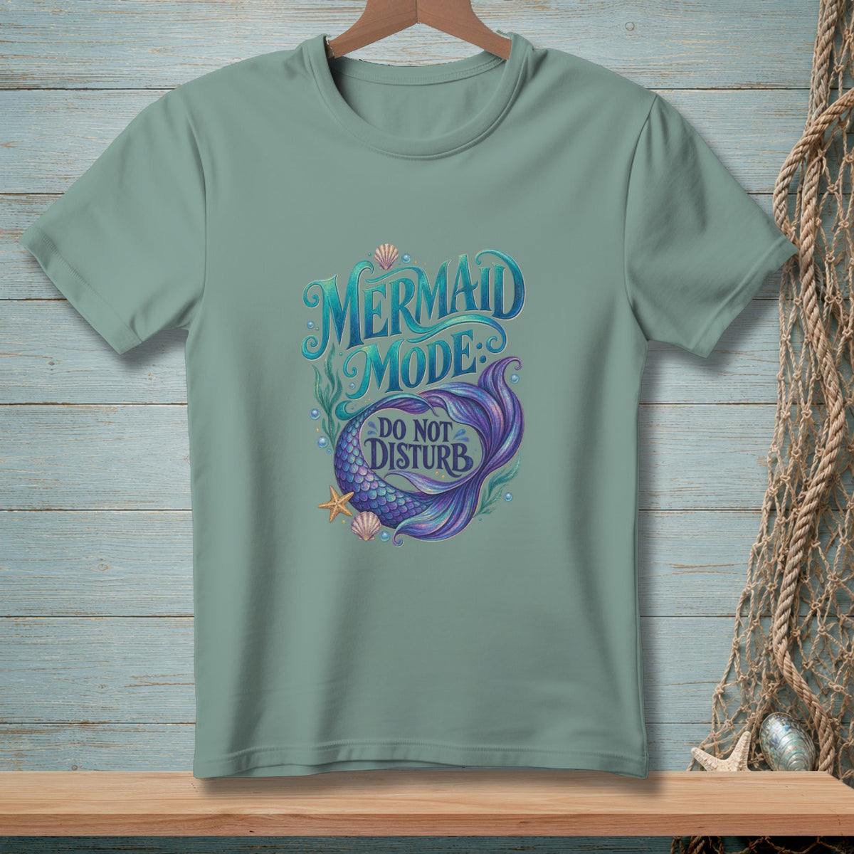 Green t-shirt with "Mermaid Mode Do Not Disturb" text and mermaid tail.
