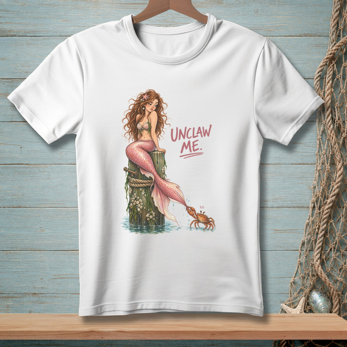 Mermaid sitting on a post with a crab pinching her tail, text "UNCLAW ME."
