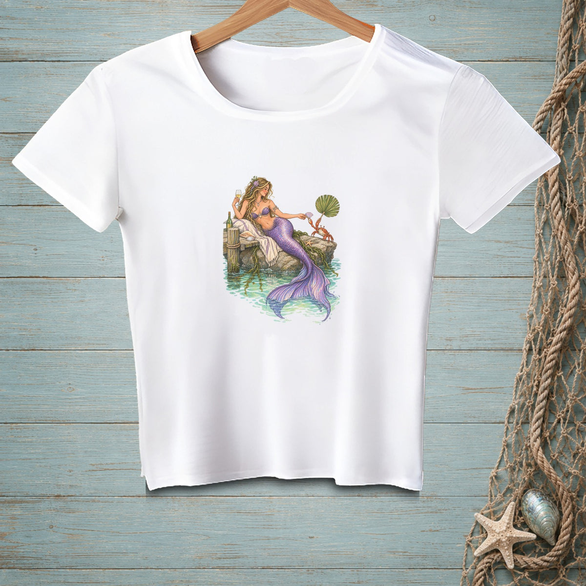 White t-shirt with illustration of a mermaid relaxing on a dock.