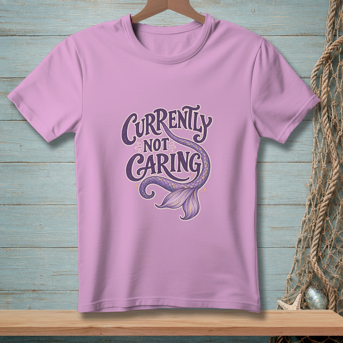 Purple t-shirt with "Currently Not Caring" text and a mermaid tail graphic.