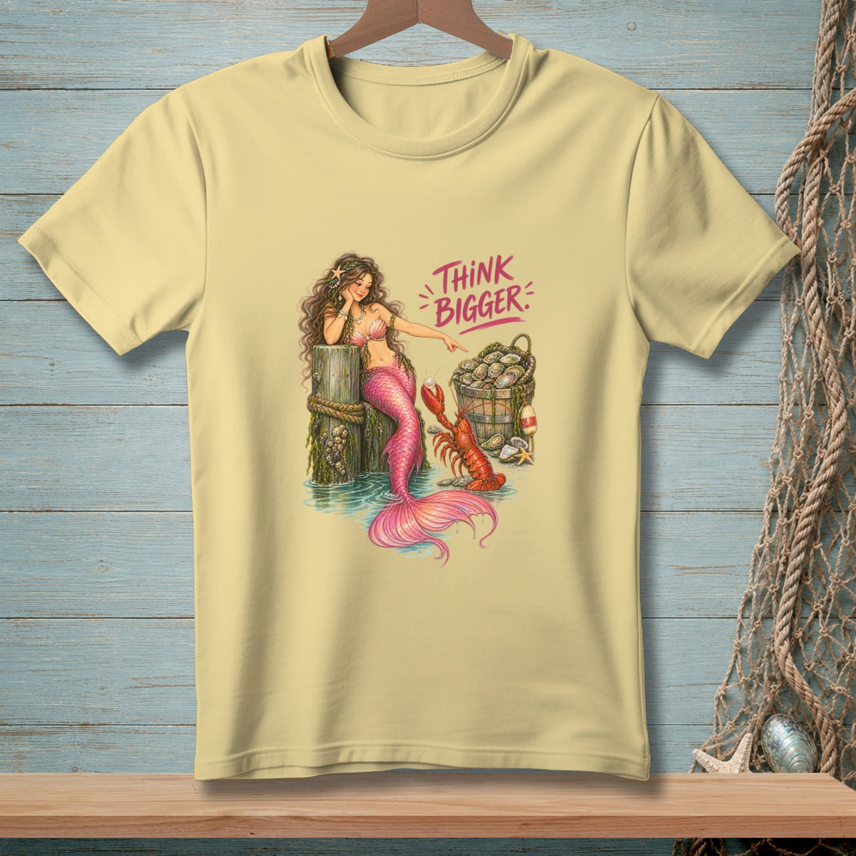 Yellow t-shirt with mermaid, lobster, oysters, and "Think Bigger" text.