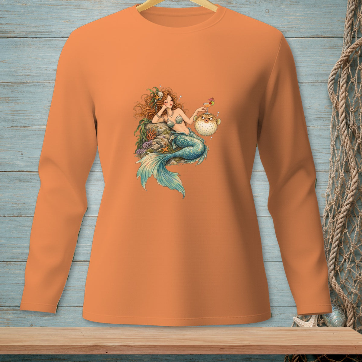 Orange long-sleeve shirt featuring a mermaid with a pufferfish and a drink.