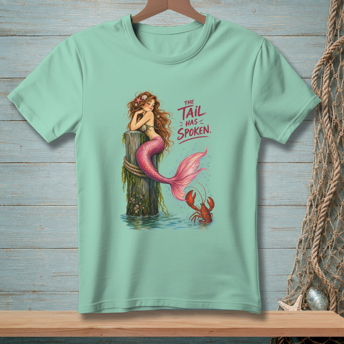 Mint t-shirt with mermaid and lobster graphic, text reads "The Tail Has Spoken."
