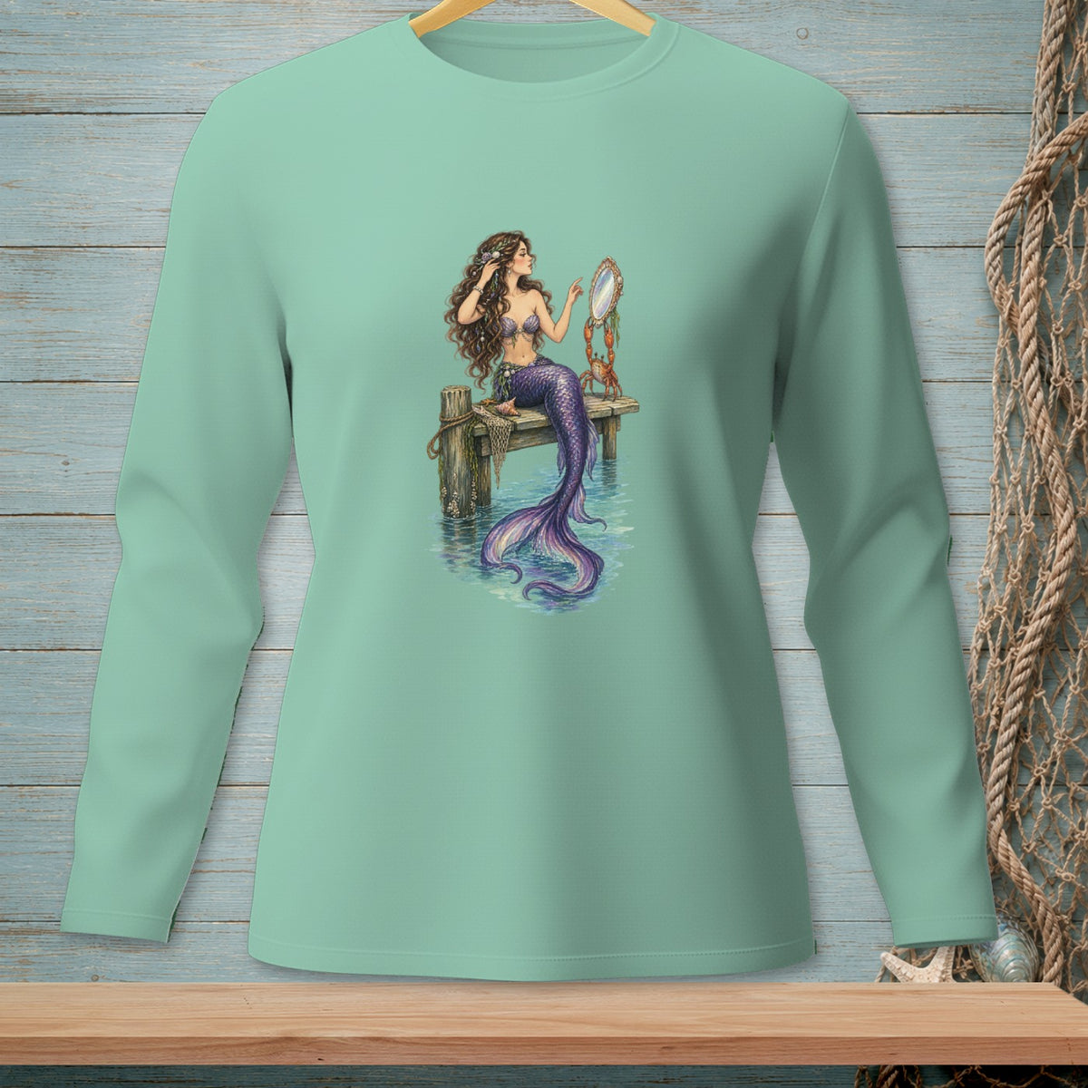 Mermaid with purple tail combing hair with a mirror on a wooden pier.