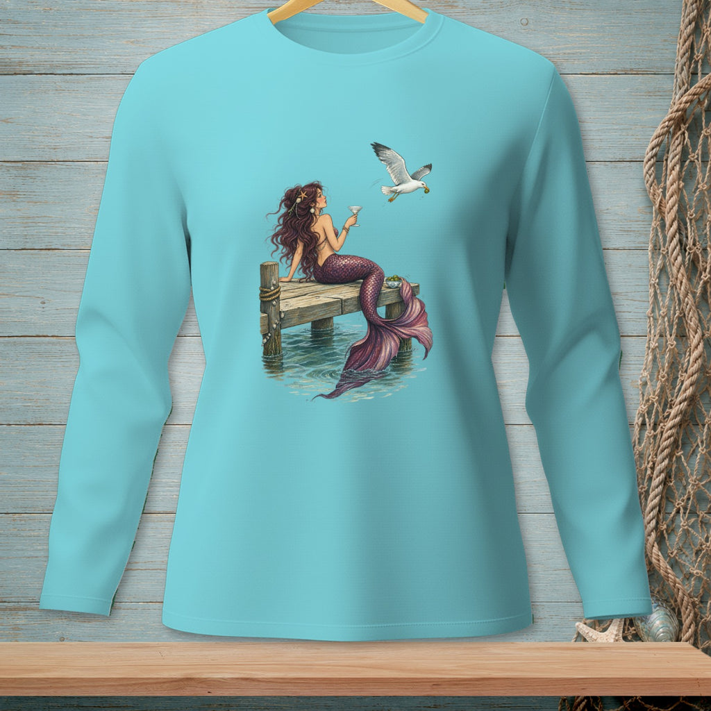 Mermaid with purple tail holding drink on dock, a seagull flies nearby.