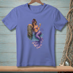 Purple t-shirt with a purple mermaid holding a cocktail and leaning on a wooden post.