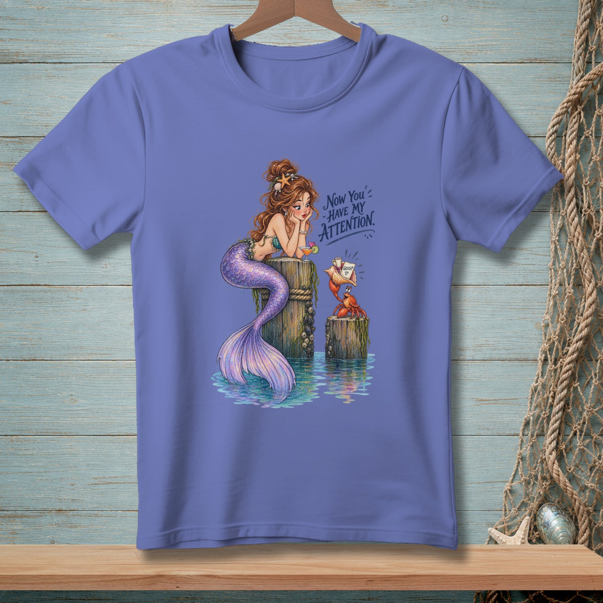 Purple t-shirt with a mermaid and crab graphic saying "Now you have my attention."