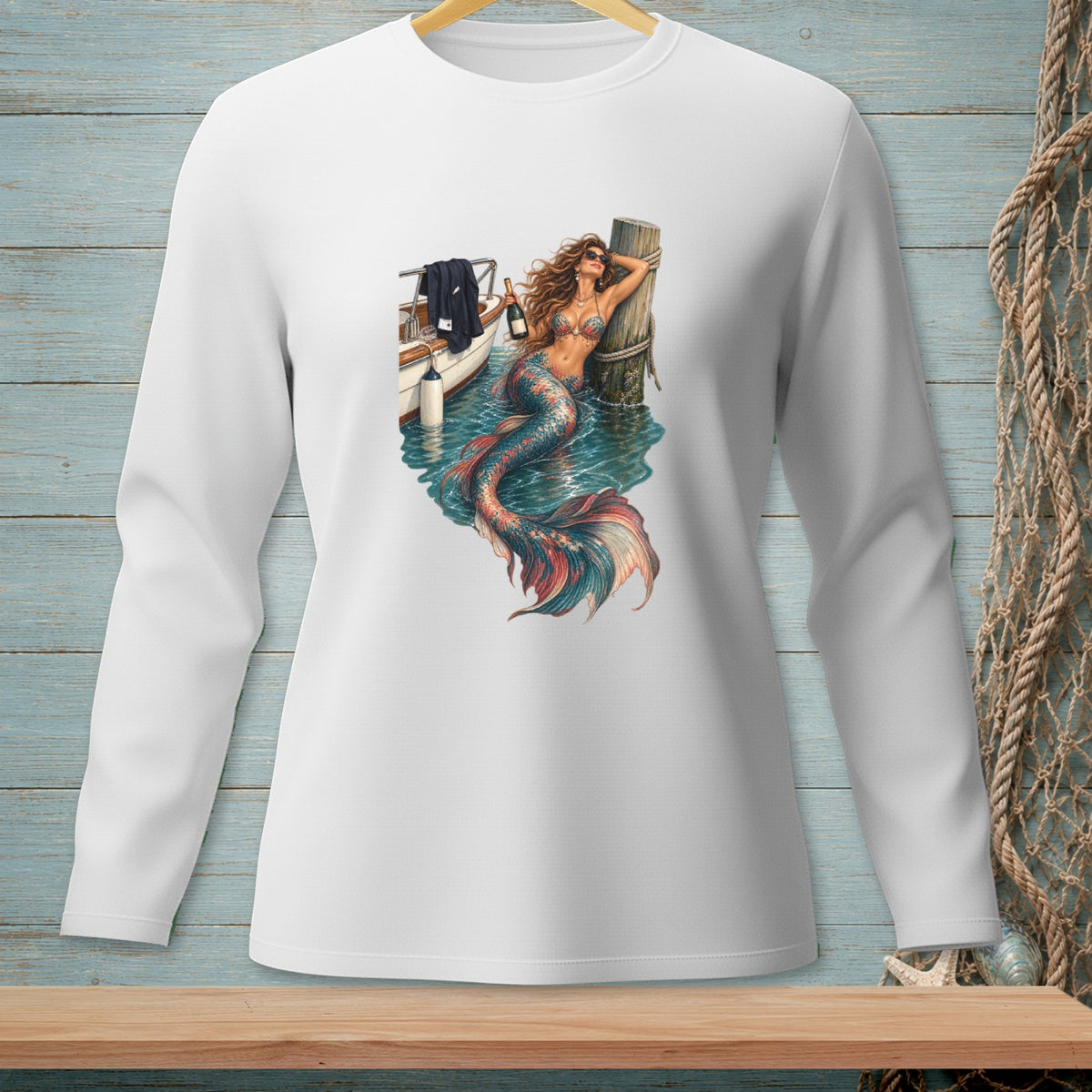 White long-sleeve shirt with a detailed print of a mermaid and boat by a pier.