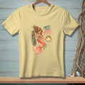 Light yellow t-shirt featuring a mermaid holding a pufferfish with text "Move Your Puff".