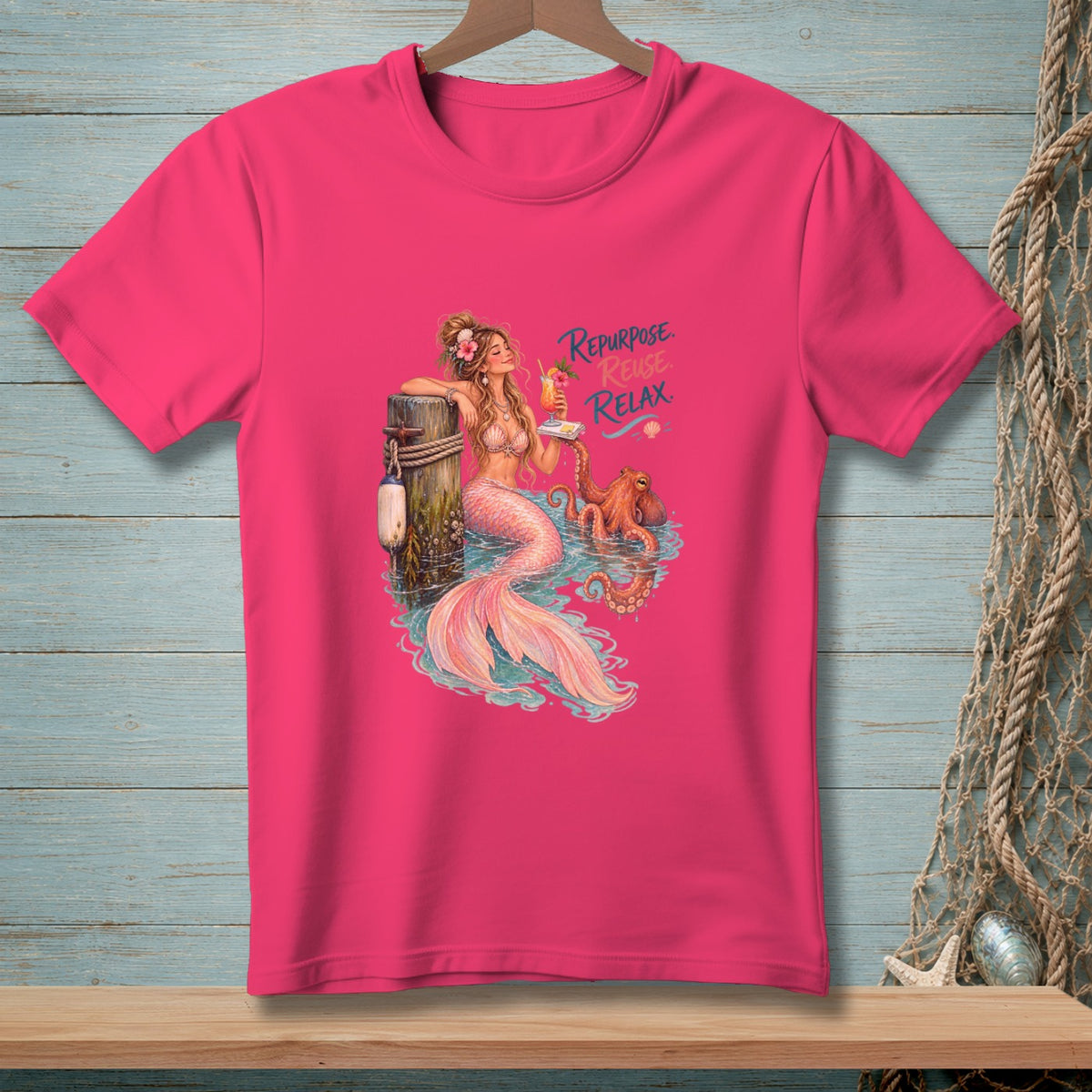 Pink t-shirt with a mermaid relaxing with an octopus and the text "Repurpose. Reuse. Relax."