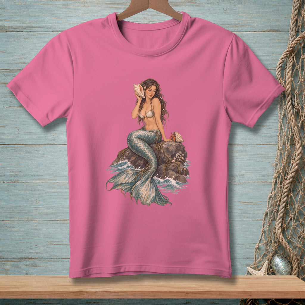 Pink t-shirt with an illustration of a mermaid sitting on a rock by the sea.