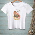 White t-shirt with a mermaid wearing sunglasses relaxing by a rock with a seagull flying above.