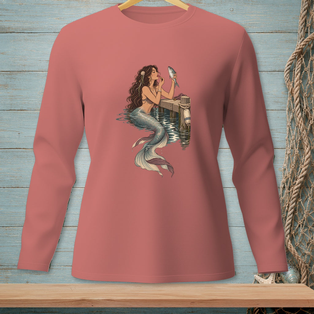 Mermaid applying makeup to a fish on a dock.
